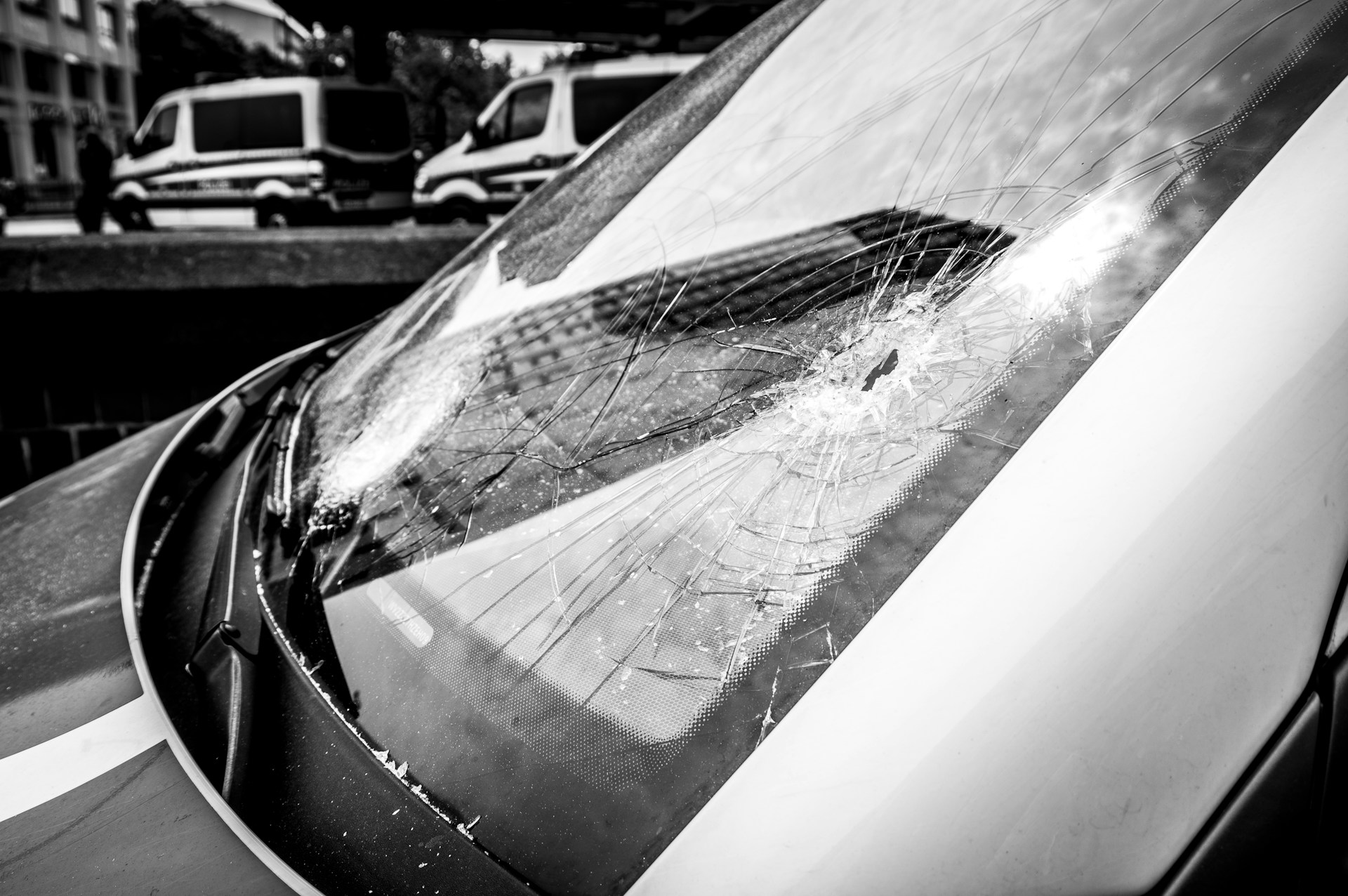 Black and white photo of broken vehicle windshield